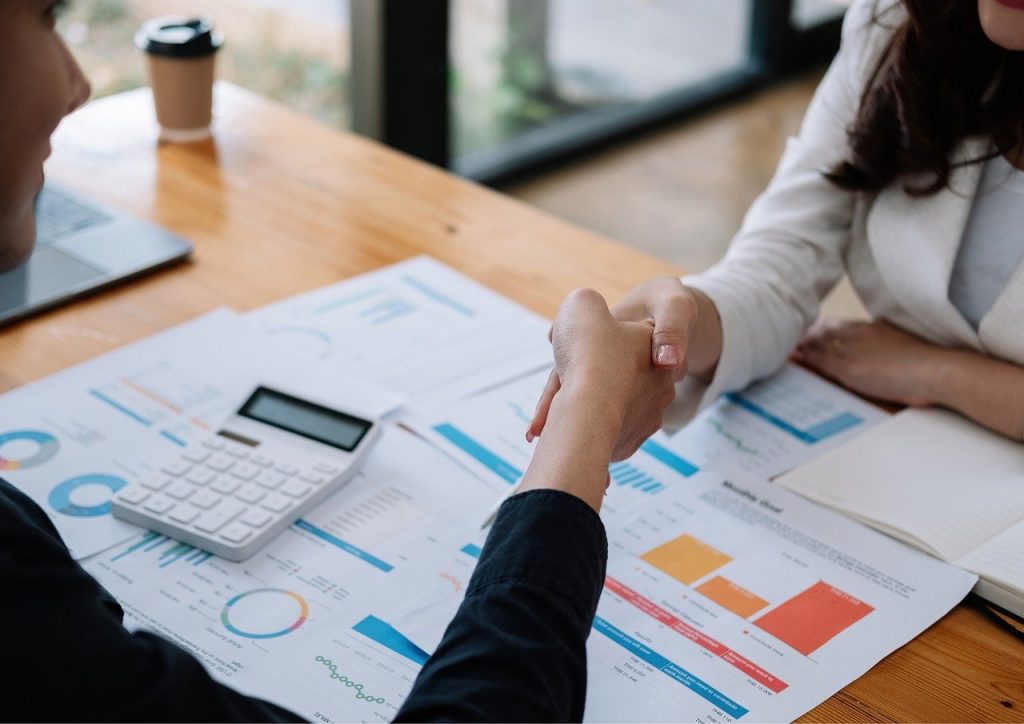 the image displayed shows two people shaking hands over a desk.